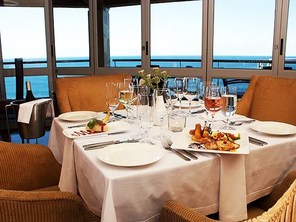 Plated meal and a glass of wine with ocean views at the Pinnacle Point clubhouse